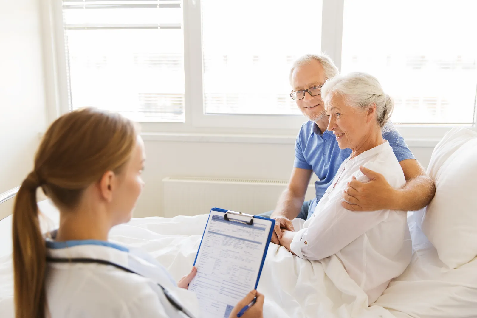 Läkare och äldre patient vid ett vårdsamtal.